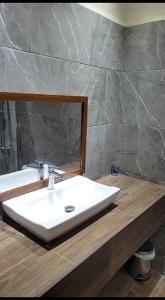 y baño con lavabo blanco y espejo. en Hotel MarBrissa en Puerto Barrios