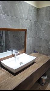 een badkamer met een witte wastafel en een spiegel bij Hotel MarBrissa in Puerto Barrios