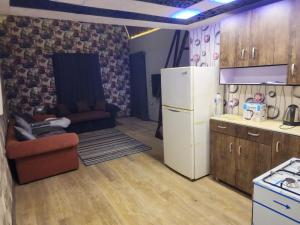 a kitchen with a white refrigerator and a couch at Privat apartment beside mall of egypt in 6th Of October