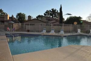 a swimming pool with chairs and a fence at Charming 2BR/2BA, BlueBarrelHome in Chandler