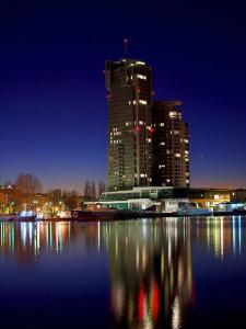 un perfil urbano con un edificio alto por la noche en Apartamenty Sea Towers, en Gdynia