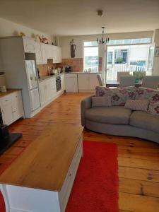 a living room with a couch and a kitchen at Fairway Haven in Dunfanaghy