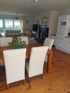 a living room with a table and white chairs at Fairway Haven in Dunfanaghy