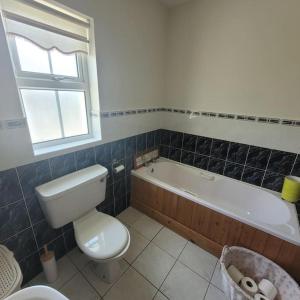 uma casa de banho com um WC e uma banheira em Fairway Haven em Dunfanaghy