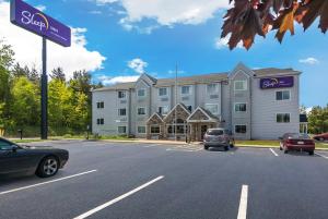 a building with cars parked in front of a street at Sleep Inn in Erie