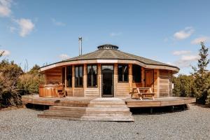 Cette grande cabane en bois dispose d'une terrasse couverte et d'escaliers. dans l'établissement Kaho - Ohakune Holiday Home with Spa, à Ohakune
