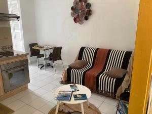 een woonkamer met een bank en een tafel bij Studio Bougainvillier Style Bohème in Marigot