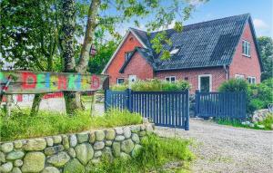 una casa con una recinzione blu e una casa in mattoni di Ferienwohnung Moewennest a Klanxbüll