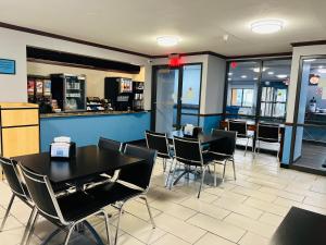 Baymont by Wyndham La Crosse/Onalaska في Onalaska: غرفة طعام مع طاولات وكراسي في مطعم