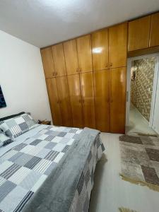 a bedroom with a bed and wooden cabinets at Apto com Wi-Fi a 200m da Praia de Copacabana/RJ - Cp3 in Rio de Janeiro