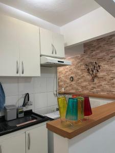 a kitchen with white cabinets and colorful chairs on a counter at Apto com Wi-Fi a 200m da Praia de Copacabana/RJ - Cp3 in Rio de Janeiro