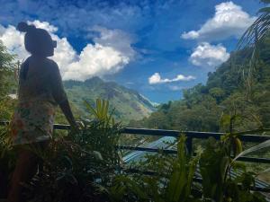 uma mulher de pé numa varanda com vista para as montanhas em Ella Lucky Panoramic em Ella