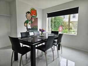 a dining room with a black table and chairs at Light & Airy Heart of Central Kelburn! in Wellington