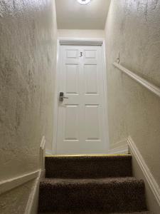 una puerta blanca en un pasillo con escaleras en Peaceful living, en Hazleton