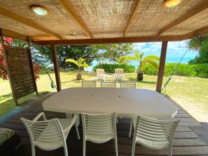 a white table and chairs under a wooden roof at MOOREA - Fare Tiki Beach in Haapiti