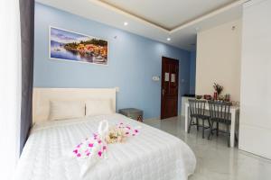 een slaapkamer met een wit bed met bloemen erop bij HOTEL & APARTMENT VY VAN in Vung Tau