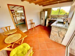 uma cozinha com um balcão, uma mesa e cadeiras em Casa de Orion em Ayangue