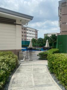a courtyard with tables and umbrellas in a building at Twenty-Nine Cats - SMDC Cheer Residences Marilao in Marilao