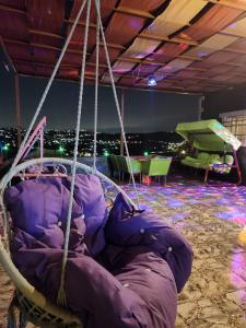 a purple pillow swing with a view of the city at shalyh tal birin in Şarrūt