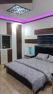 a bedroom with a large bed with a purple lighting at shalyh tal birin in Şarrūt