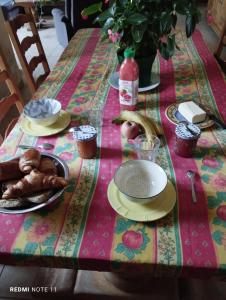 una mesa con un mantel con comida. en Chambre d'hôtes en Provence, au pied du Luberon "Les Coquelicots" en La Tour-dʼAigues