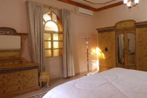 Un dormitorio con una cama y una cómoda y una ventana. en Alnessayem Farmhouse, en Sayḩ aş Şaqlah 65 fotos más