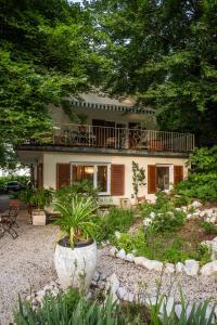 ein Haus mit einem Balkon und einem Hof mit Pflanzen in der Unterkunft Gästehaus Wallner in Velden am Wörthersee