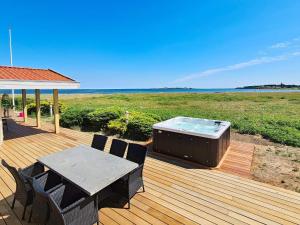 a deck with a hot tub and a table and chairs at Holiday home Haderslev XXVI in Haderslev