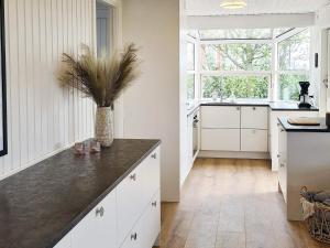 a kitchen with white cabinets and a black counter top at Holiday home Haderslev XXVI in Haderslev