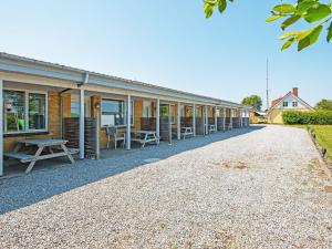 a row of houses with chairs and tables on a gravel road at 4 person holiday home in Sydals-By Traum in Østerby