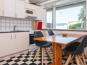 a kitchen with a wooden table and black chairs at Seaside Escape in Kegnaes - By Traum Ferienwohnungen in Østerby +39 photos
