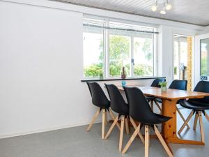 een eetkamer met een houten tafel en stoelen bij Apartment Sydals II in Østerby