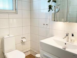 Baño blanco con aseo y lavamanos en Holiday home Sundbyberg en Sundbyberg