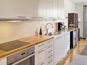 uma cozinha com armários brancos e um lavatório em Holiday home Sundbyberg em Sundbyberg