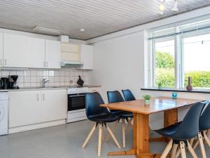 een keuken met een houten tafel en blauwe stoelen bij Apartment Sydals II in Østerby