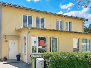 a yellow house with windows and a clock on it at Holiday home Sundbyberg in Sundbyberg