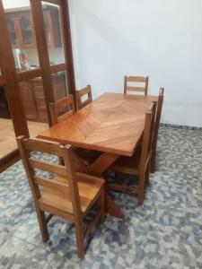 een houten eettafel met 2 stoelen en een tafel en stoelen bij Casa Grande in Iquitos