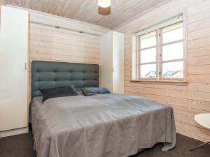 1 dormitorio con 1 cama grande en una pared de madera en Holiday home Harboøre XXIII, en Harboør