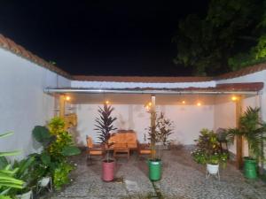 un patio con mesa, sillas y macetas en Casa Grande en Iquitos