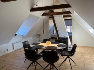 a dining room with a table and black chairs at Holiday home Svaneke LXII in Svaneke