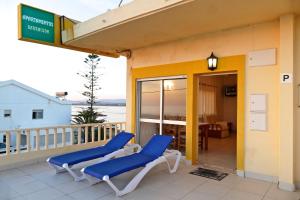 Un balcón con sillas azules y vistas al océano. en Apartamentos Barracuda, en Faro