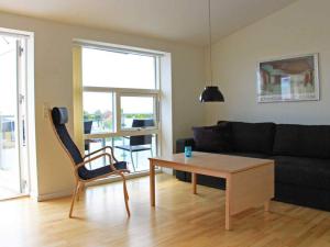 - un salon avec un canapé noir et une table dans l'établissement Holiday home Nexø LX, à Neksø
