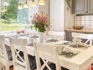 Holiday home BILLINGSFORS II في Billingsfors: طاولة غرفة طعام بيضاء مع كراسي بيضاء وطاولة بيضاء وكرسي
