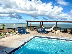 una piscina en un patio con vistas al océano en MARINAS PRAIA FLAT, en João Pessoa