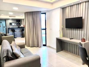 Una sala de estar con un sofá y un televisor de pantalla plana. en MARINAS PRAIA FLAT, en João Pessoa