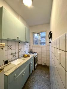 a kitchen with green cabinets and a sink and a window at departamento con balcón in Mar del Plata