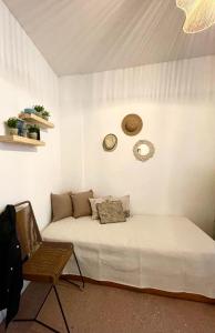 a white room with a bed and a chair at departamento con balcón in Mar del Plata