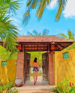 una mujer caminando por las puertas de un edificio en Full Moon Village Resort, en Mui Ne