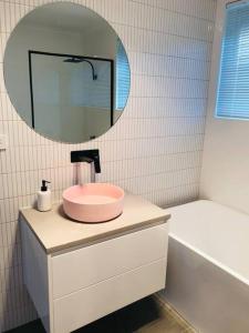 bagno con lavandino rosa e specchio di The Blush House a Hobart