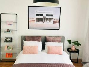 荷伯特的住宿－The Blush House，一间卧室配有带粉色和白色枕头的床